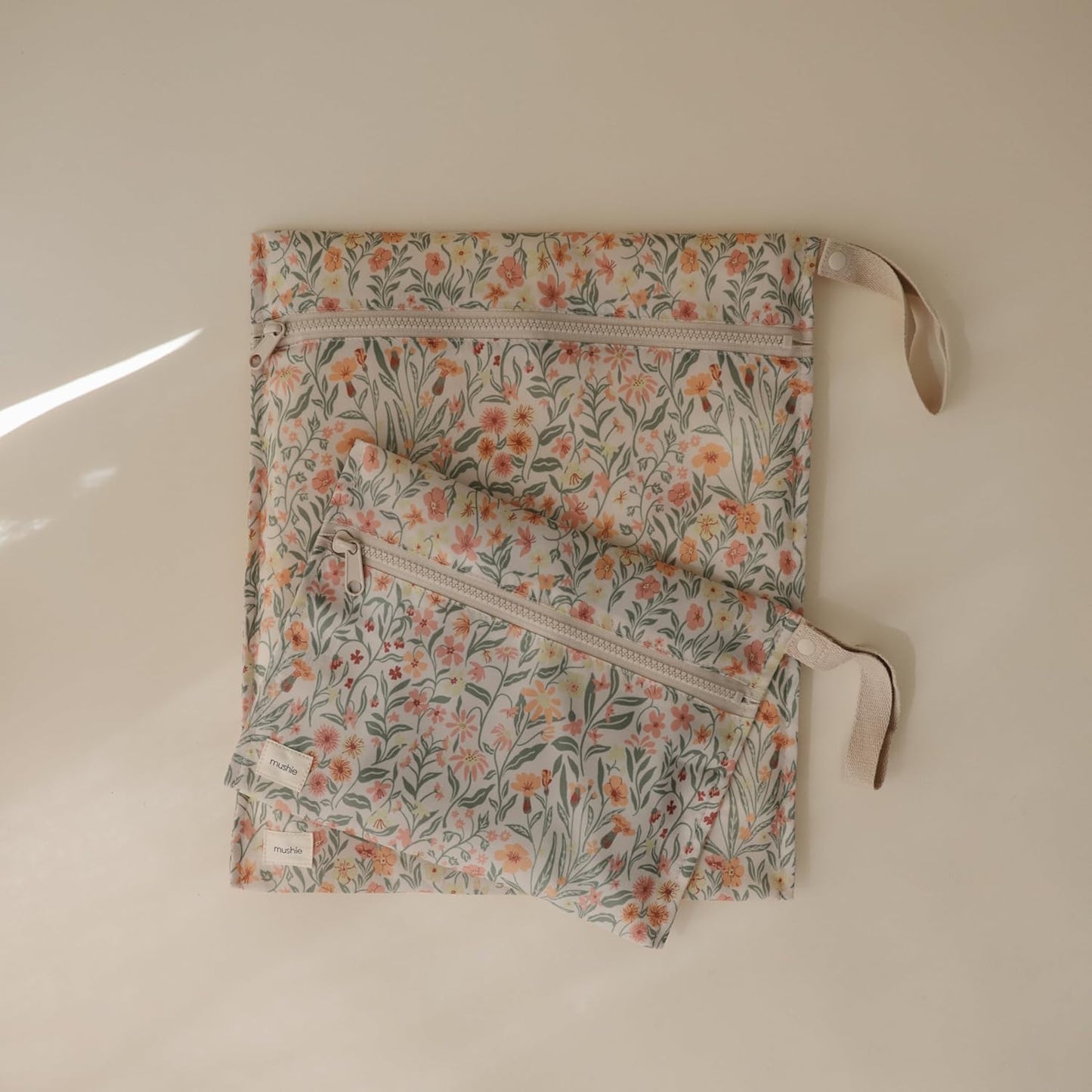 mushie Water Resistant Wet Bags | Large & Small Reusable Storage Bag for Baby Items and Travel | Zippered Pockets with Handle | Machine Washable, Set of 2 (Pastel Blooms)